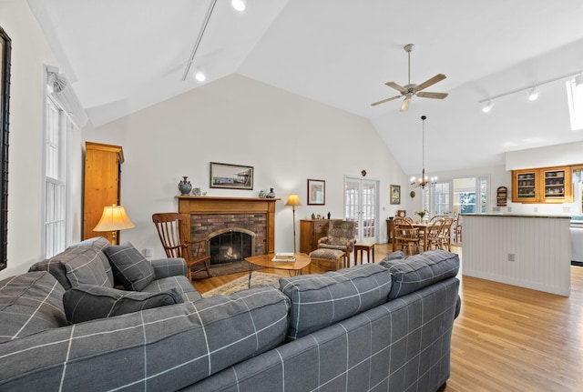 21 Gramps Way S, Chatham, MA 02659 - living area featuring rail lighting, vaulted ceiling, ceiling fan, light wood-style floors, and a fireplace