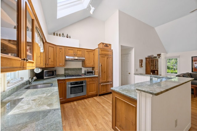 21 Gramps Way S, Chatham, MA 02659 - kitchen with appliances with stainless steel finishes, high vaulted ceiling, under cabinet range hood, light wood-style floors, and brown cabinets