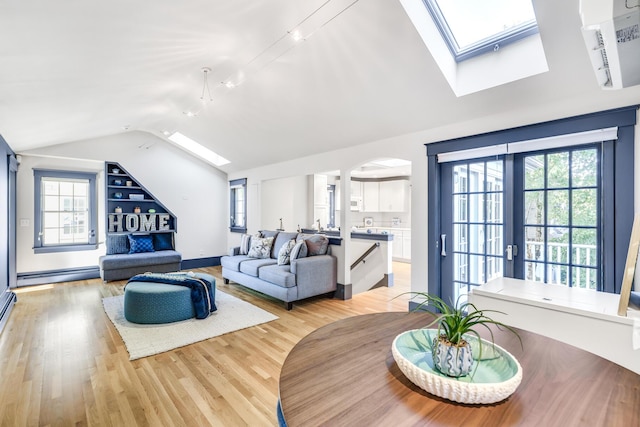 living room featuring a baseboard heating unit, lofted ceiling with skylight, light wood-type flooring, and a healthy amount of sunlight