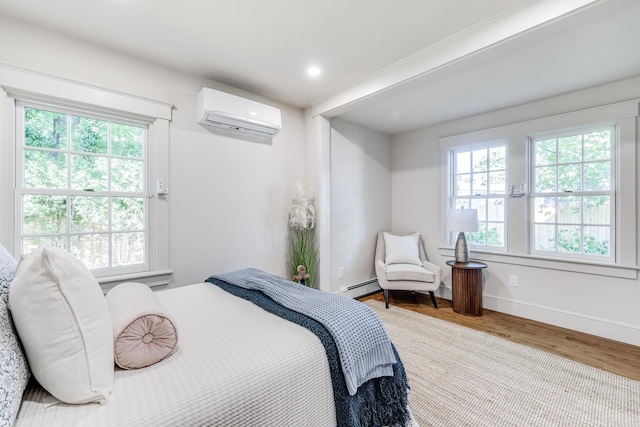 bedroom with hardwood / wood-style flooring, a baseboard radiator, multiple windows, and a wall mounted air conditioner