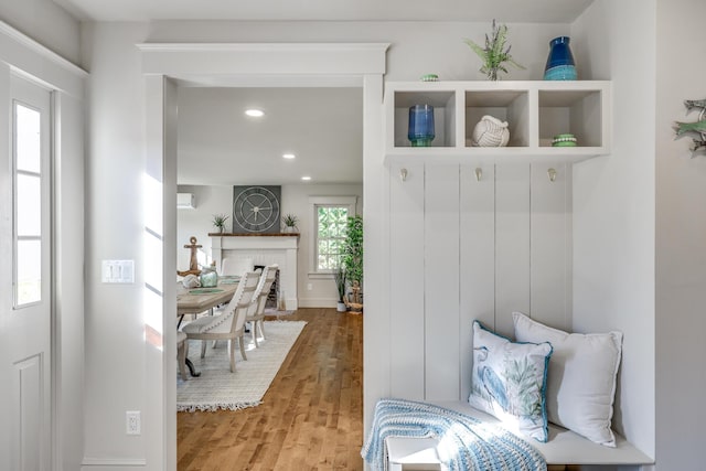 mudroom with a brick fireplace and wood-type flooring