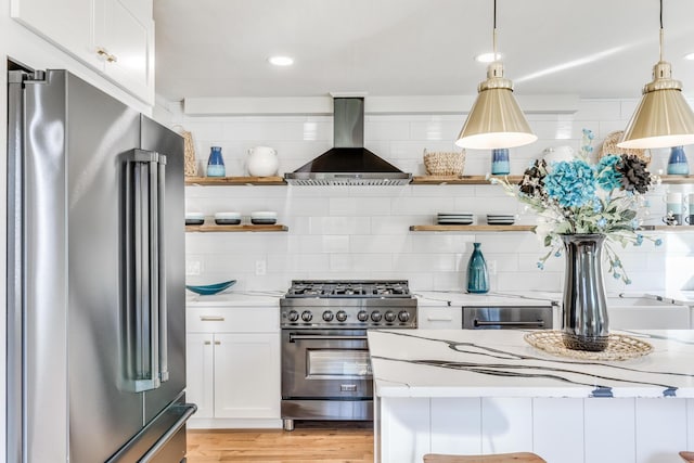 kitchen featuring white cabinetry, decorative light fixtures, high end appliances, and island exhaust hood