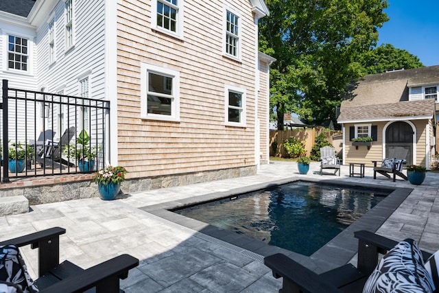 view of swimming pool with a patio area and an outbuilding