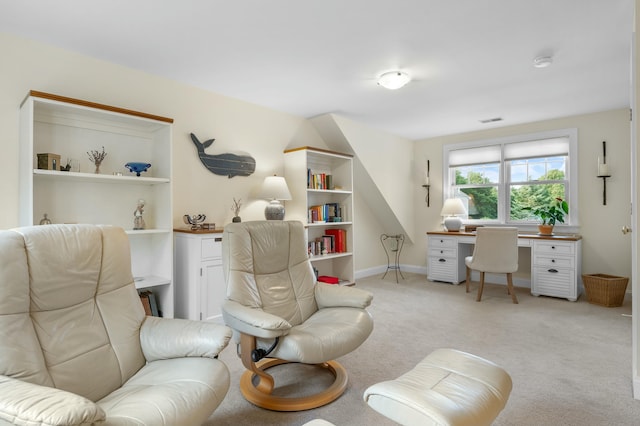 living area featuring baseboards, visible vents, and light colored carpet