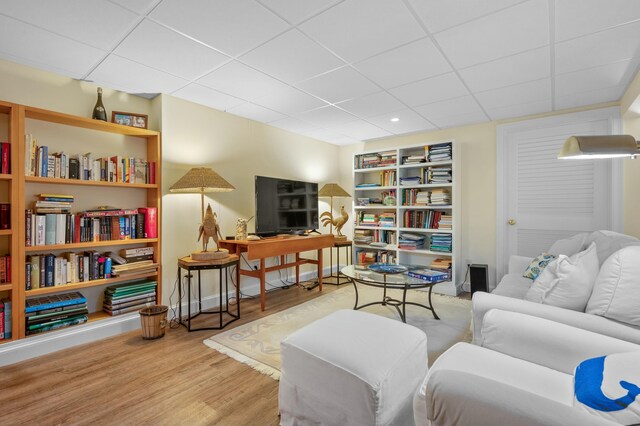 sitting room with a paneled ceiling and wood finished floors