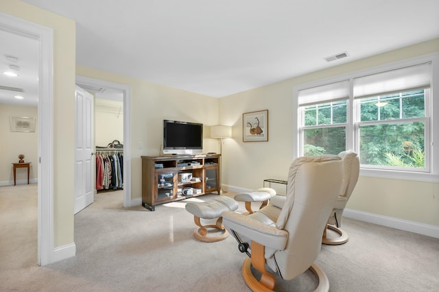 living room featuring visible vents, light carpet, and baseboards