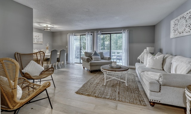 living room with light hardwood / wood-style floors and a textured ceiling