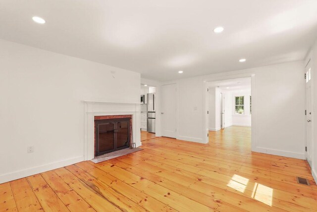2 Little Cove Ln, Orleans, MA 02653 - unfurnished living room featuring light wood-style floors, a brick fireplace, recessed lighting, and baseboards
