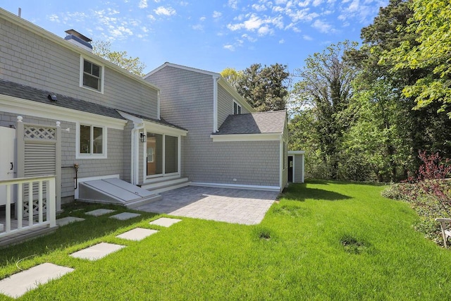 2 Little Cove Ln, Orleans, MA 02653 - back of house featuring a yard, a patio, a shingled roof, and a chimney