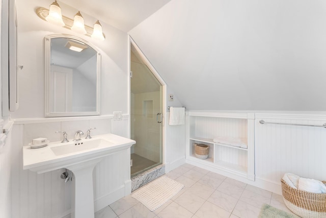 23 Crowell Ln, Tisbury, MA 02568 - bathroom featuring marble look tiles, a stall shower, lofted ceiling, and wainscoting