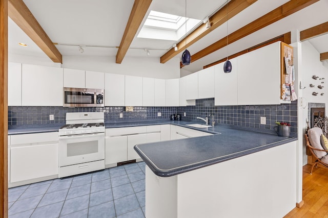 5 Great Hills Rd, Truro, MA 02666 - kitchen with stainless steel microwave, white gas range, dark countertops, and white cabinetry