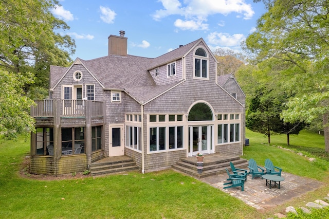 20 James Pond Way, West Tisbury, MA 02575 - back of property with a chimney, a yard, roof with shingles, a patio area, and a wooden deck