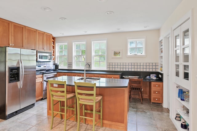 20 James Pond Way, West Tisbury, MA 02575 - kitchen with appliances with stainless steel finishes, a sink, dark countertops, brown cabinetry, and recessed lighting