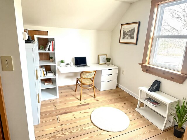 office area with vaulted ceiling, light wood-style floors, and baseboards