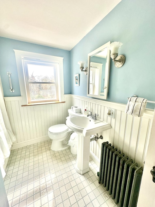 bathroom featuring toilet, radiator, and wainscoting