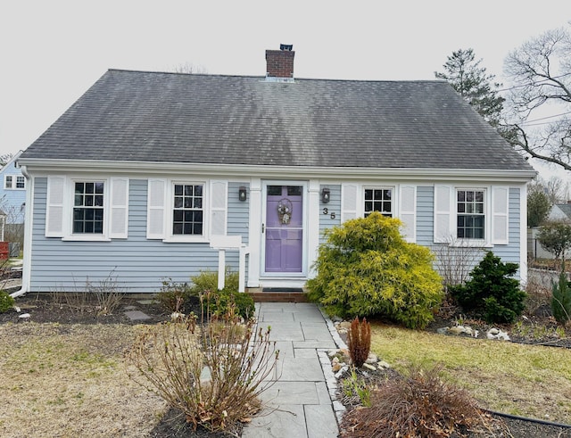 cape cod house with roof with shingles and a chimney