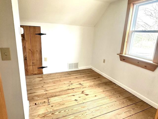 bonus room featuring visible vents, lofted ceiling, baseboards, and hardwood / wood-style floors
