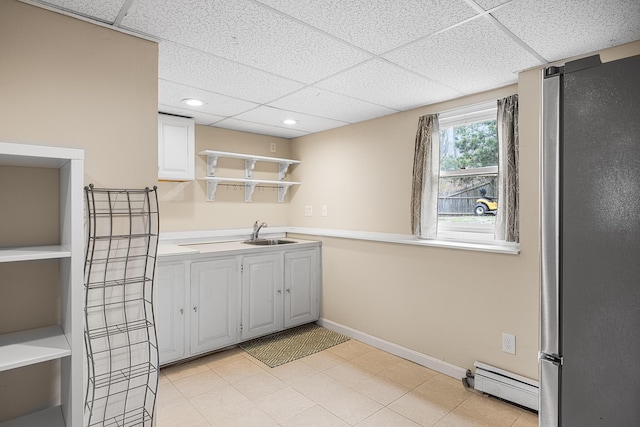 239 Upper County Rd, South Dennis, MA 02660 - kitchen with freestanding refrigerator, open shelves, baseboard heating, a paneled ceiling, and a sink