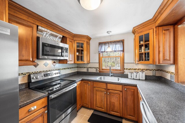 239 Upper County Rd, South Dennis, MA 02660 - kitchen featuring appliances with stainless steel finishes, a sink, dark countertops, and brown cabinetry