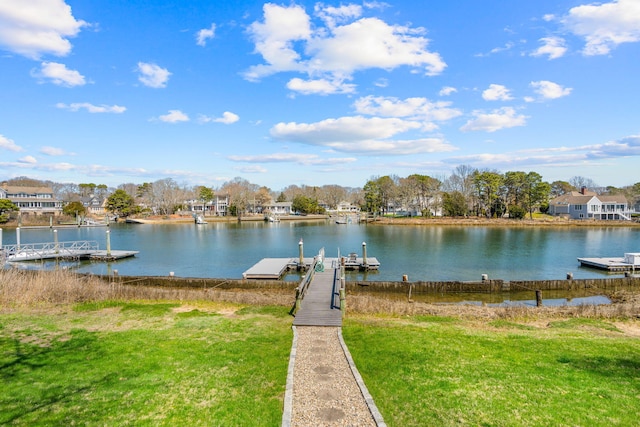 dock area with a water view and a yard