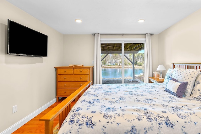 bedroom featuring baseboards, recessed lighting, wood finished floors, and access to exterior