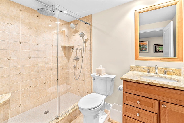 bathroom featuring vanity, baseboards, a stall shower, and toilet