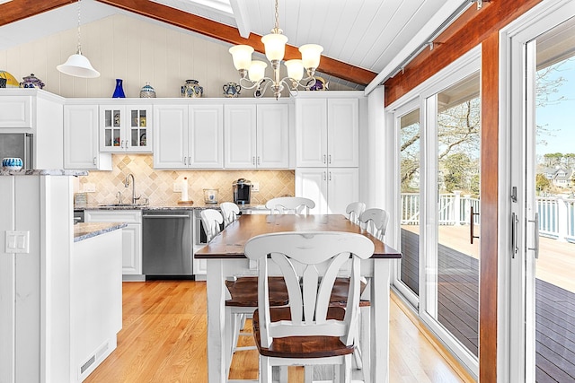kitchen with stainless steel dishwasher, lofted ceiling with beams, tasteful backsplash, and light wood-style floors