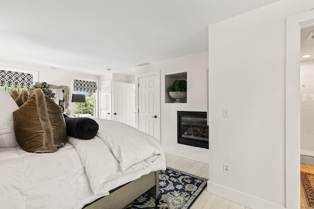 15 Sylvan Way S, Chatham, MA 02659 - bedroom featuring wood finished floors, a tile fireplace, ensuite bathroom, and baseboards