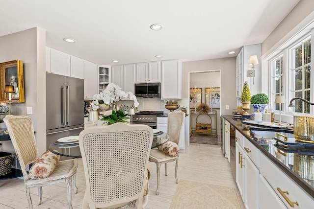 15 Sylvan Way S, Chatham, MA 02659 - kitchen with stainless steel appliances, a sink, white cabinets, glass insert cabinets, and decorative backsplash