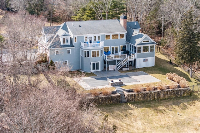 back of house with fence, stairway, a lawn, a chimney, and a patio