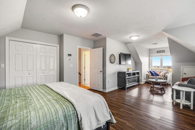 bedroom featuring dark wood-style floors, visible vents, lofted ceiling, and baseboards