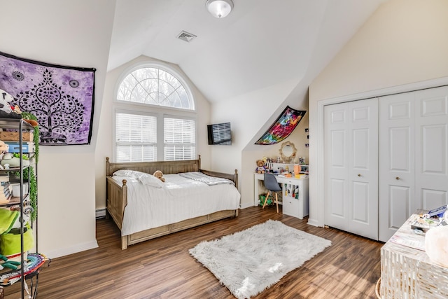 bedroom with visible vents, baseboards, lofted ceiling, wood finished floors, and a closet