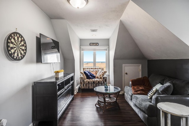 living area featuring visible vents, baseboards, wood finished floors, and vaulted ceiling