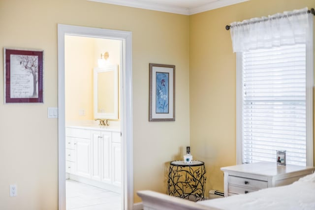 bedroom with a sink, a baseboard radiator, ensuite bath, and crown molding