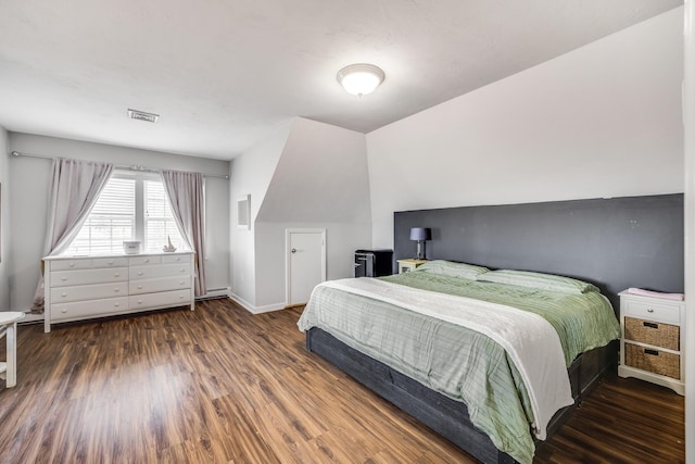 bedroom with visible vents, a baseboard radiator, baseboards, and wood finished floors