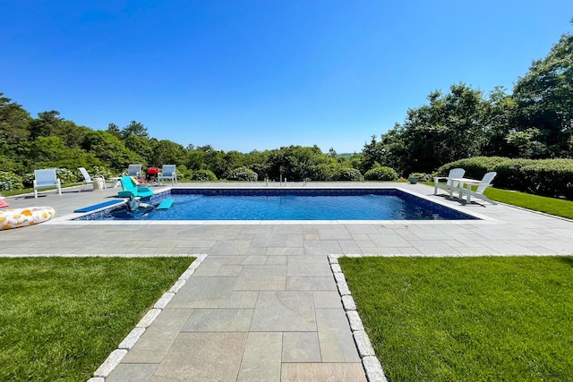 outdoor pool with a lawn and a patio area