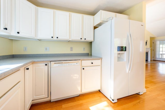 kitchen featuring light wood finished floors, white cabinets, white appliances, and light countertops