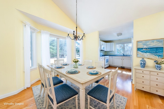 115 Pine Hill Blvd, Mashpee, MA 02649 - dining room featuring a chandelier, light wood-style floors, high vaulted ceiling, and baseboards