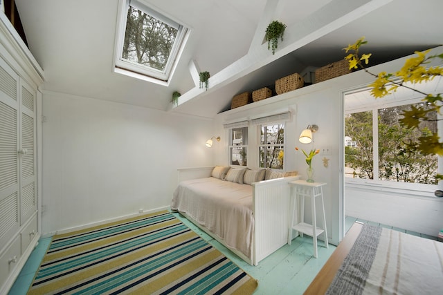 bedroom with high vaulted ceiling and a skylight
