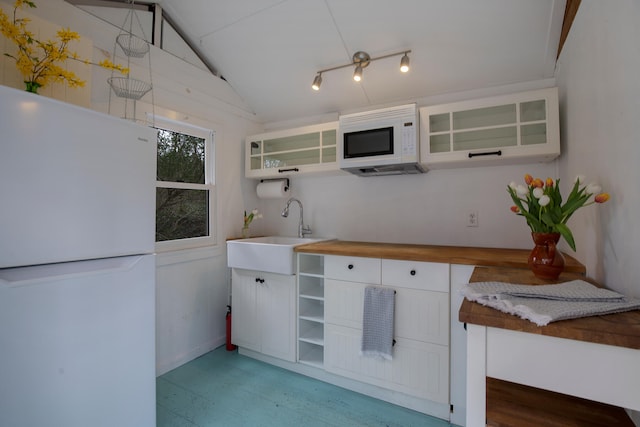 kitchen with white appliances, white cabinetry, open shelves, and a sink