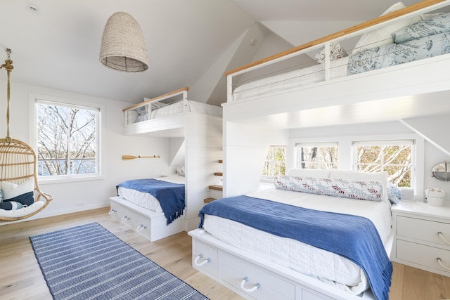 bedroom with light hardwood / wood-style floors and lofted ceiling