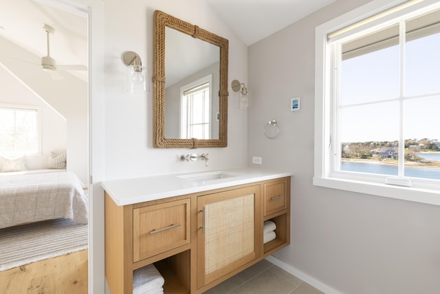 bathroom with ceiling fan, tile patterned flooring, lofted ceiling, and vanity