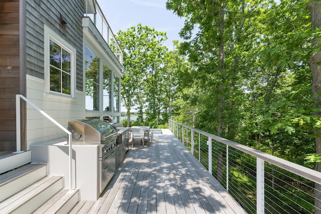 wooden terrace featuring exterior kitchen and area for grilling