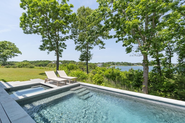 view of swimming pool featuring an in ground hot tub, a water view, and a yard