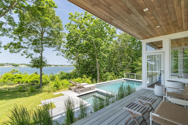 view of swimming pool with a patio area, a yard, and a water view