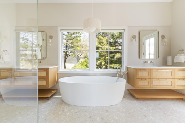 bathroom featuring backsplash, a washtub, and vanity