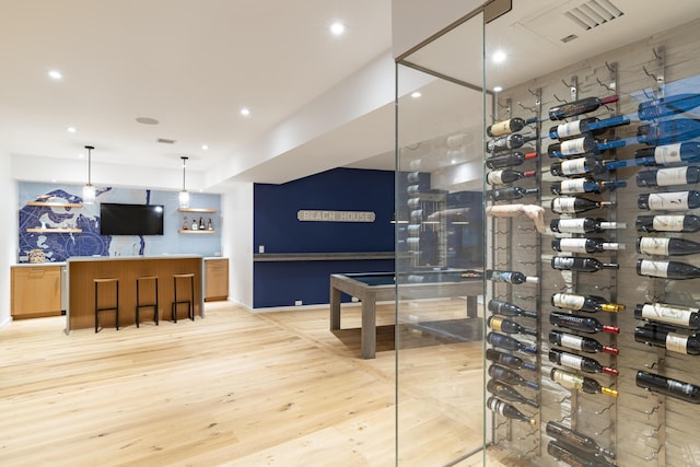 wine cellar with light hardwood / wood-style flooring and indoor bar