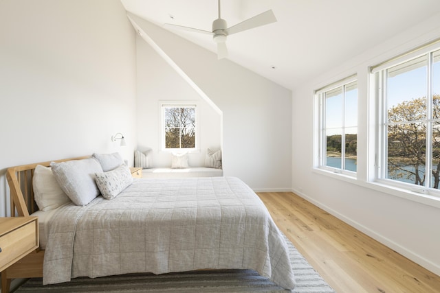 bedroom with light wood-type flooring, vaulted ceiling, and ceiling fan