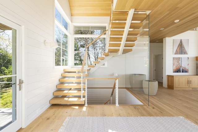 stairs featuring wooden walls and wood-type flooring