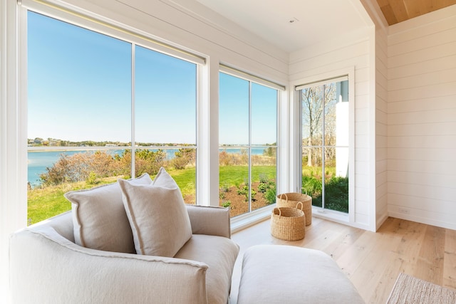 sunroom featuring a water view